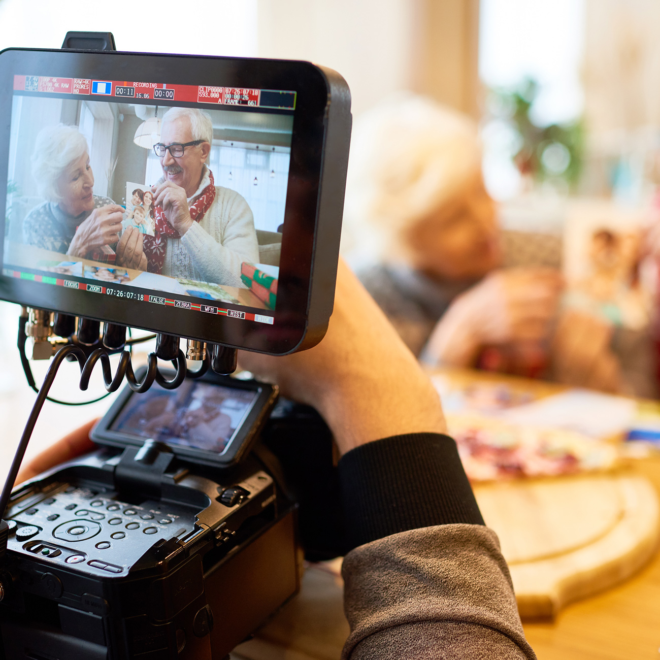 a professional style camera recording a video of senior citizens cooking